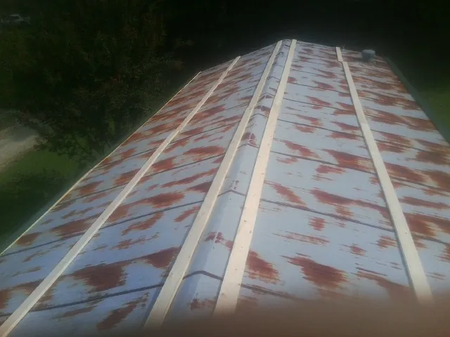 Rusted metal roof panels with new wood purlins before replacement — Storm Damage Roof Repair in Mapleton by Roofing Brothers
